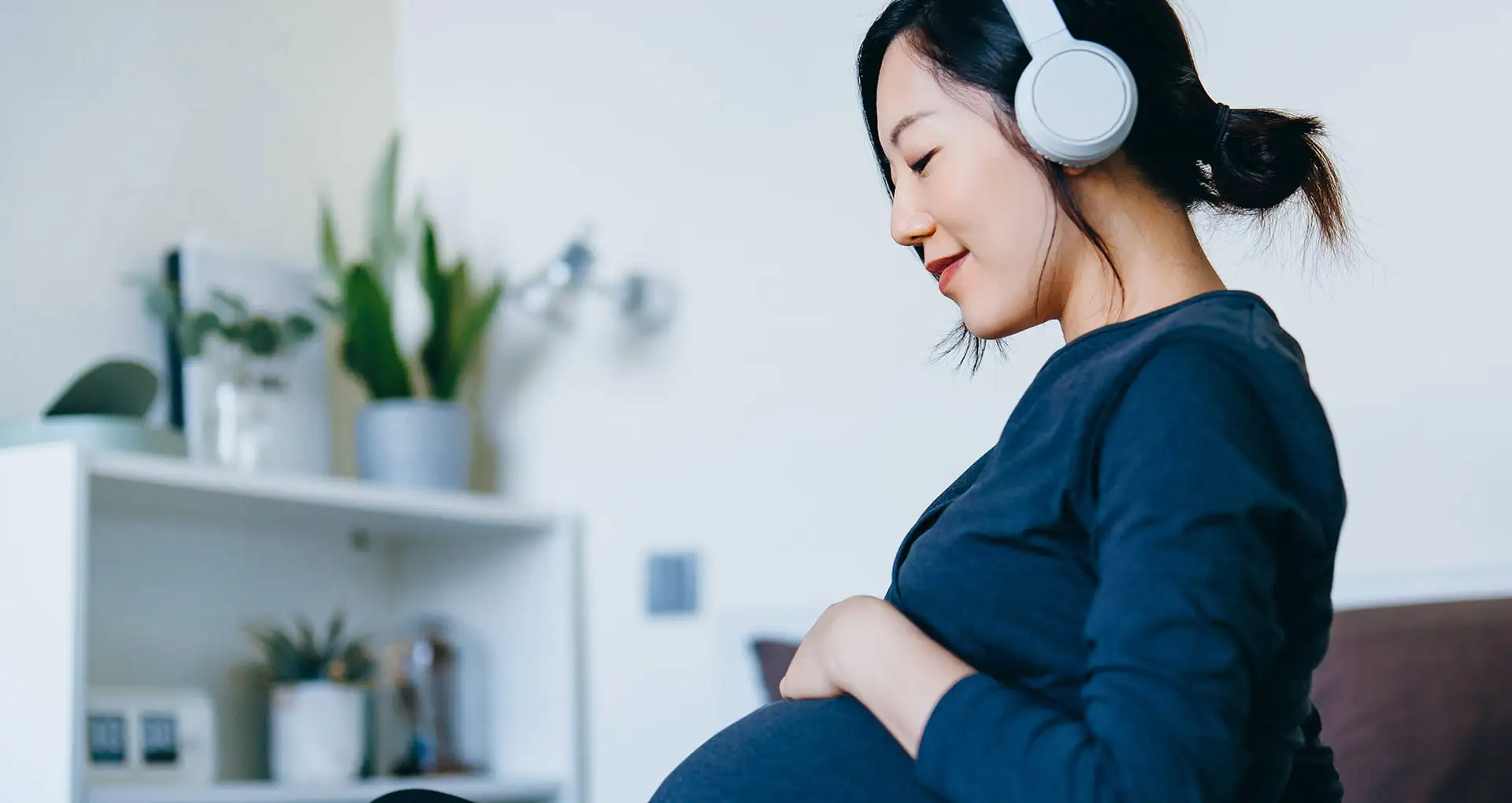 Relaxed gentleman who is mindfully tending to his indoor plants in his home environment.