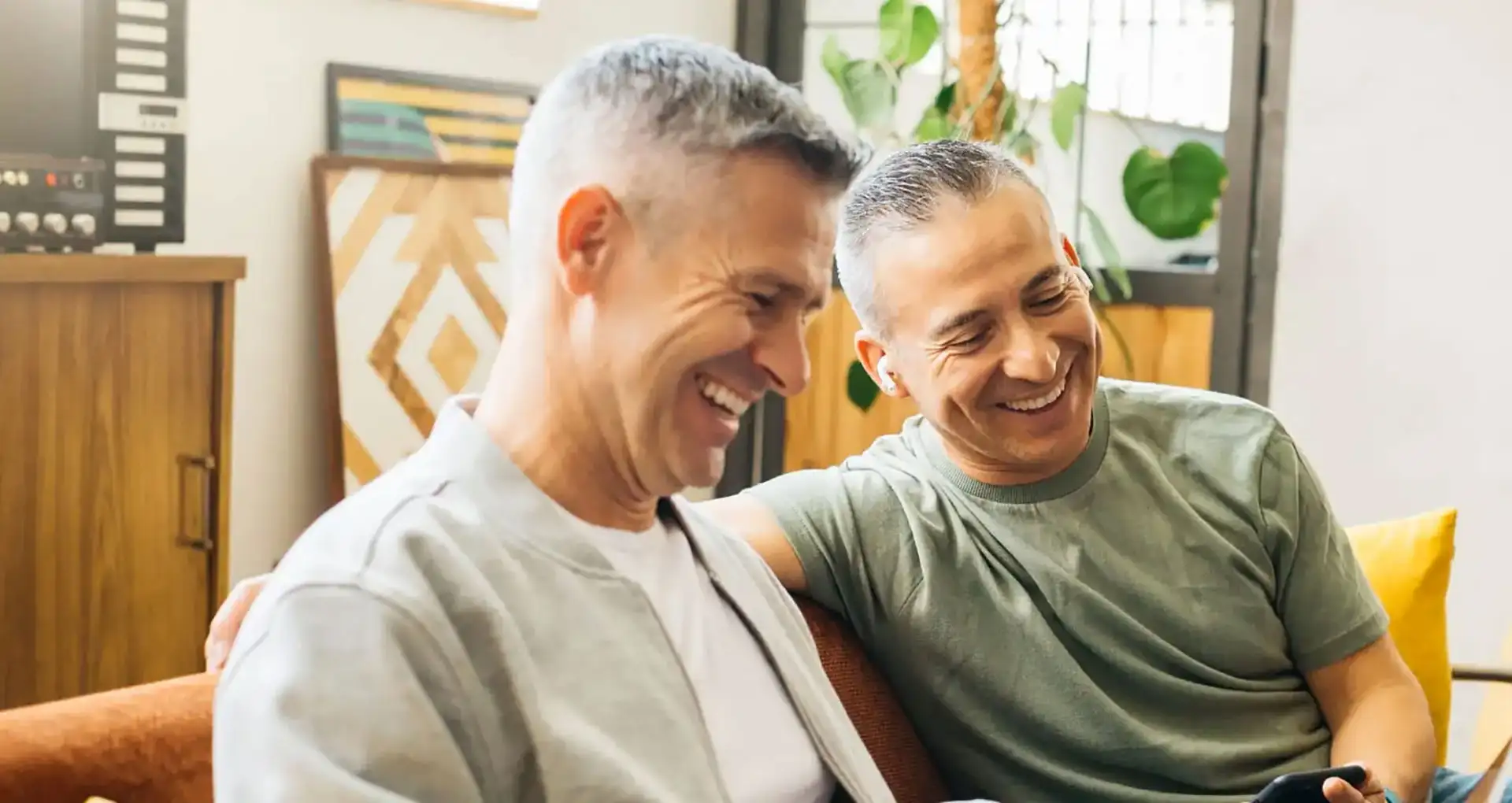 Relaxed gentleman who is mindfully tending to his indoor plants in his home environment.