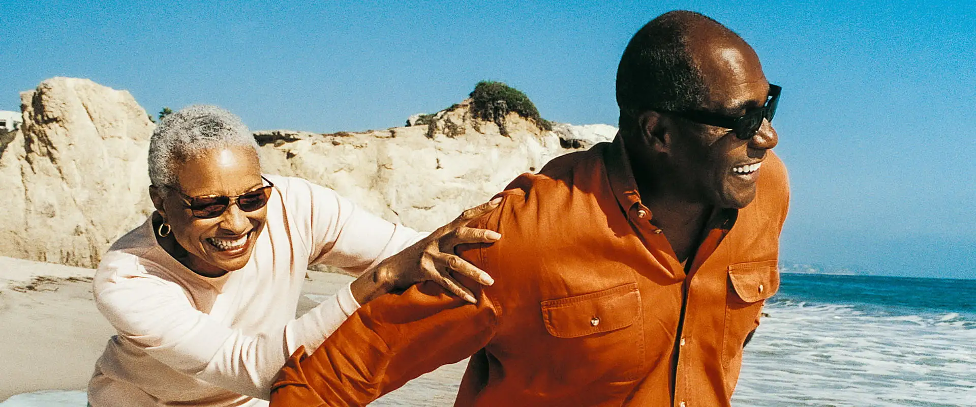 Woman in swimsuit and swimming hat enjoying a cold water swim in a lake on a brisk day.